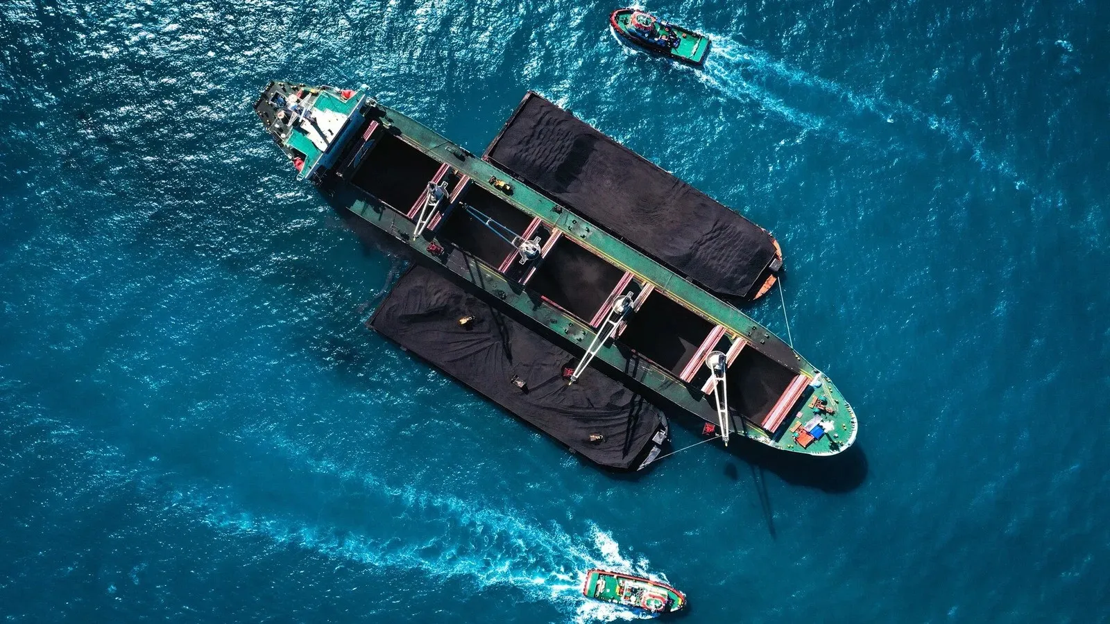 Coal barges alongside a mother vessel, seen from above